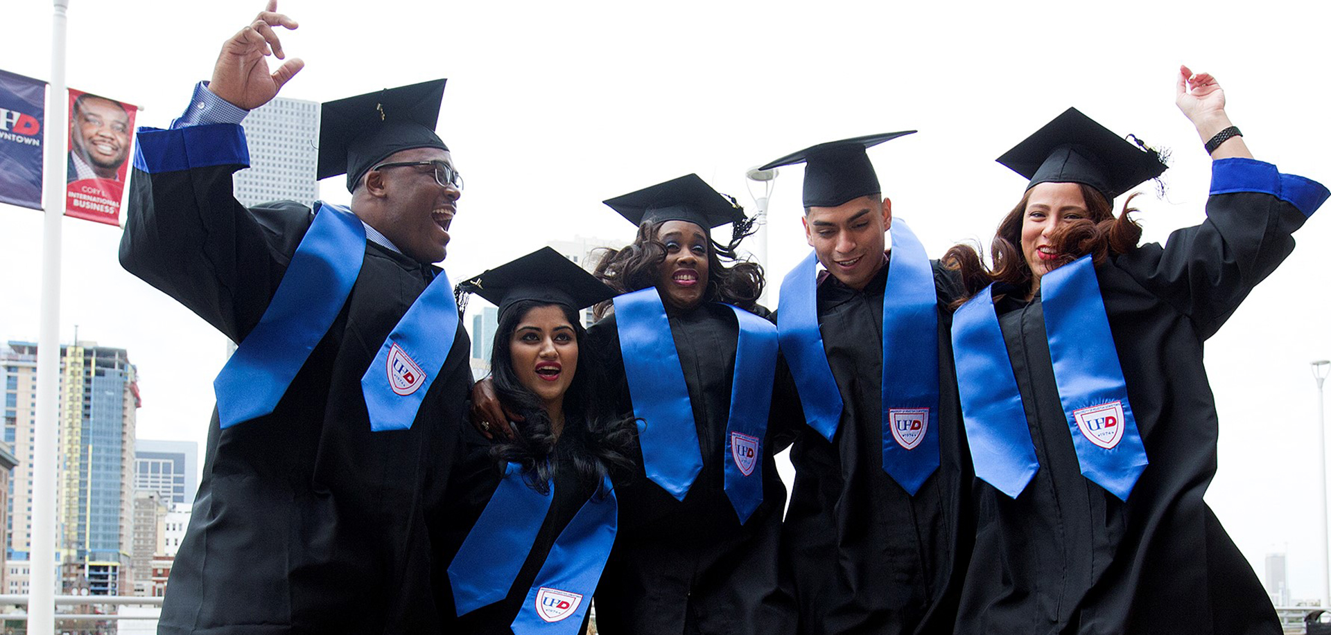 Graduates Jumping in Commencement Caps and Gowns