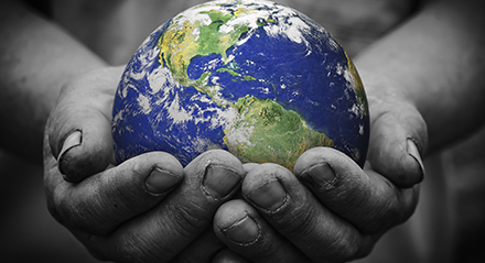 human hands holding a globe of the world