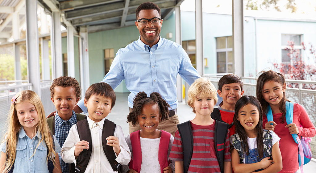 A male teacher with a group of young students.