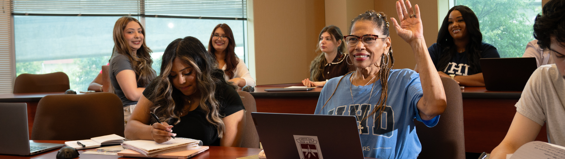 a group of students in class sitting at a desk