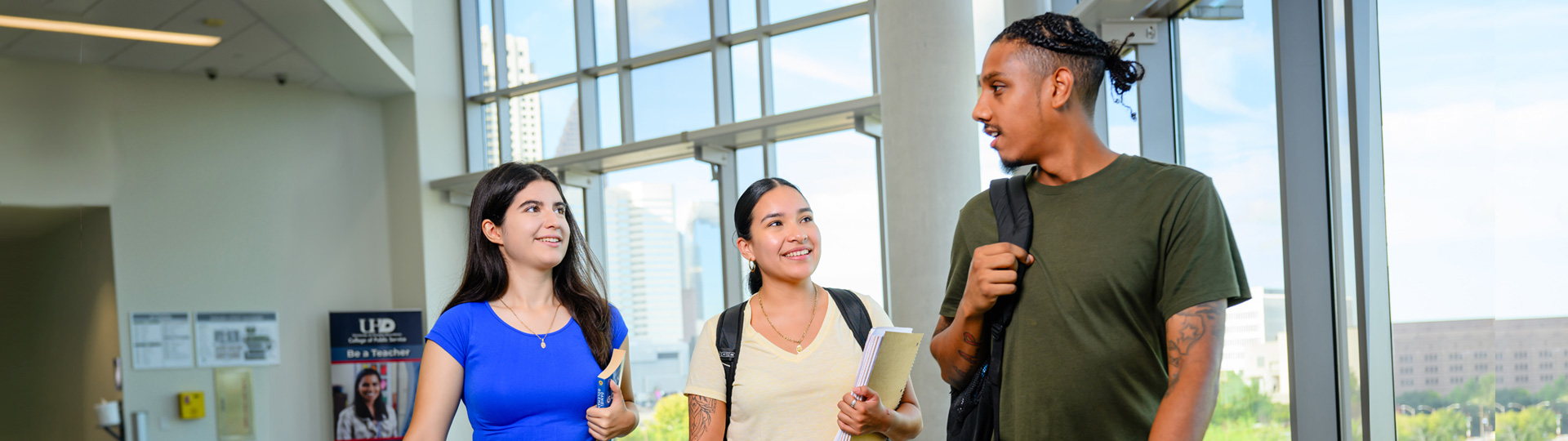 UHD students walking and chatting in a hallway