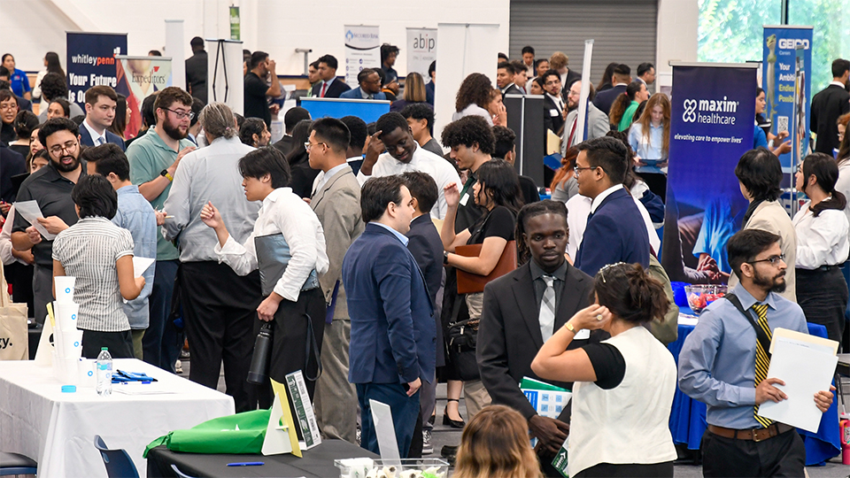 Students and alumni interacting with businesses at the career fair