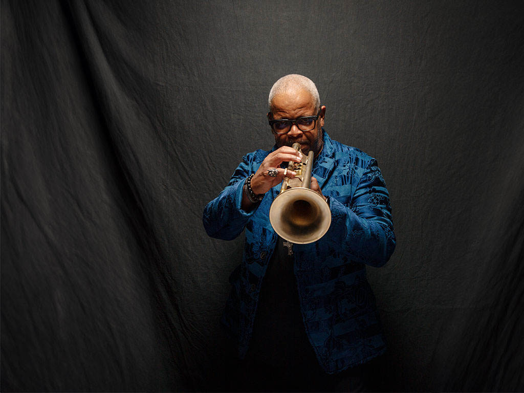 Terence Blanchard playing the trumpet in front of a black backdrop