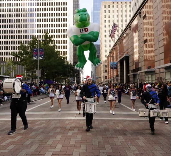 parade volunteers, drumline, and university cheerleaders at the thanksgiving day parade in downtown houston