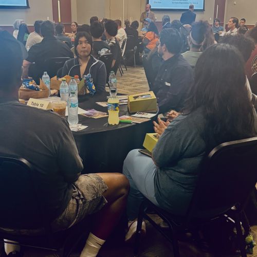 Students seated at roundtables during the Center for Public Deliberation event
