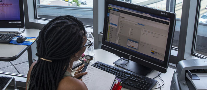 Student seen from her back and working on a computer