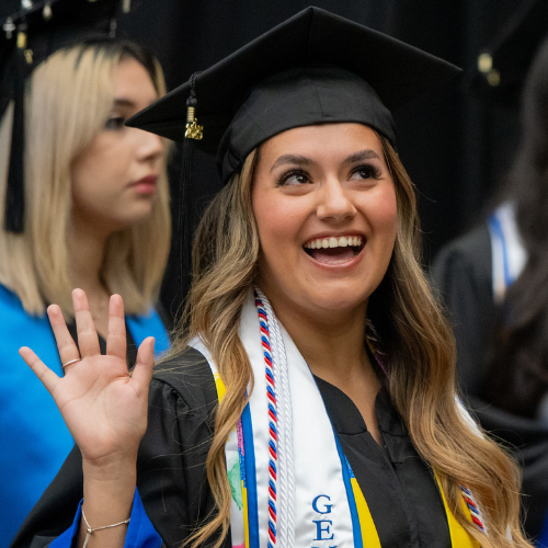 A University of Houston-Downtown student wears a cap, gown, and first generation student stole at the university's spring 2025 commencement ceremony