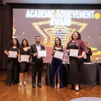 A group of UHD students hold award certificates at One Main Event