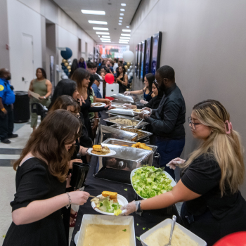 UHD students and staff stand at a buffet line at One Main Event 