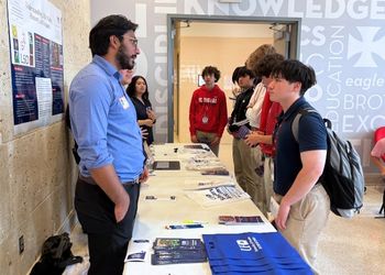 A high school student listens to an Organic Chemistry student from UHD 