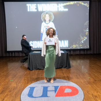 UHD student athlete holds an award certificate 